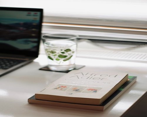 organized work desk with water and natural light